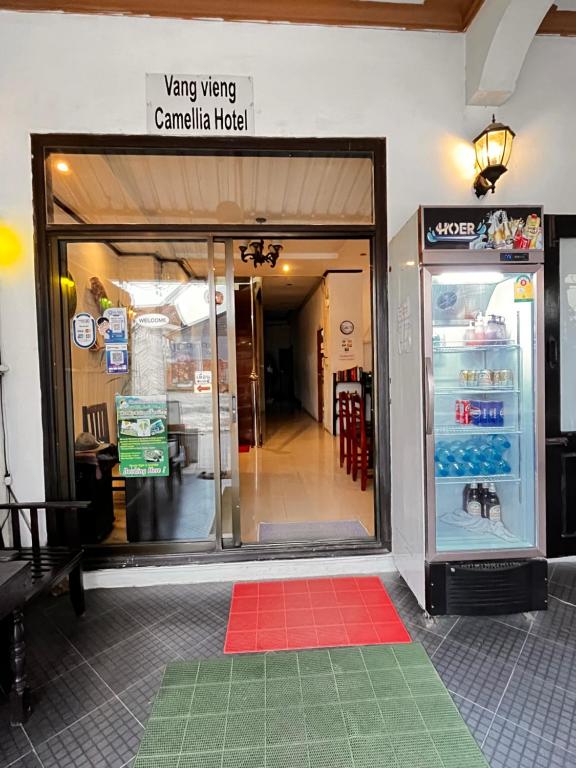 an entrance to a canadianican hospital with a red and green mat in front at Camellia Hotel in Vang Vieng