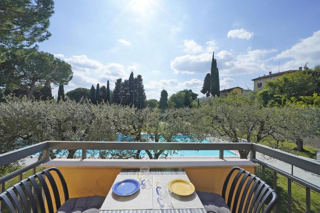 a table and chairs on a balcony with a view at Olive Garden Garda - pool & view in Moniga