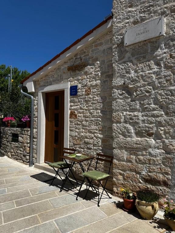 a stone building with two chairs and a table outside at Casa Borgo in Bale
