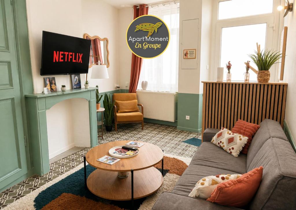 a living room with a couch and a table at Maison 2 chambres avec bureau - Proche gare in Saint-Omer