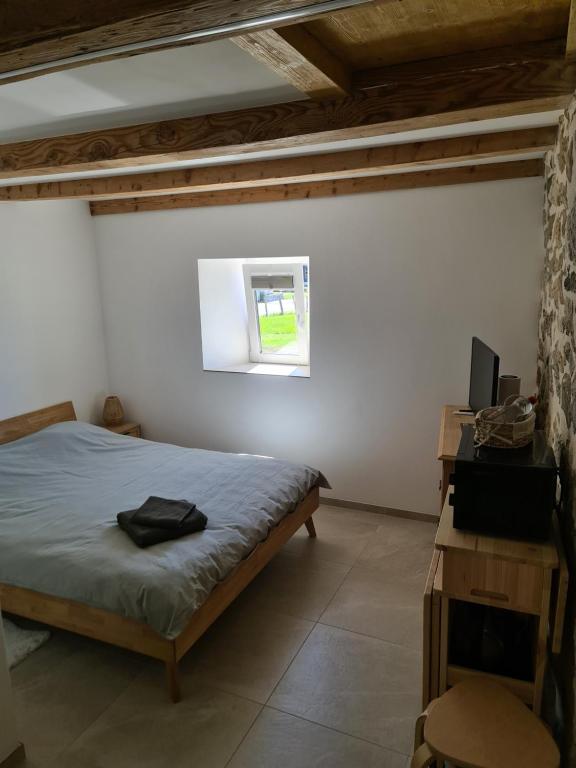 a bedroom with a bed and a window at Au petit nid in Vilars