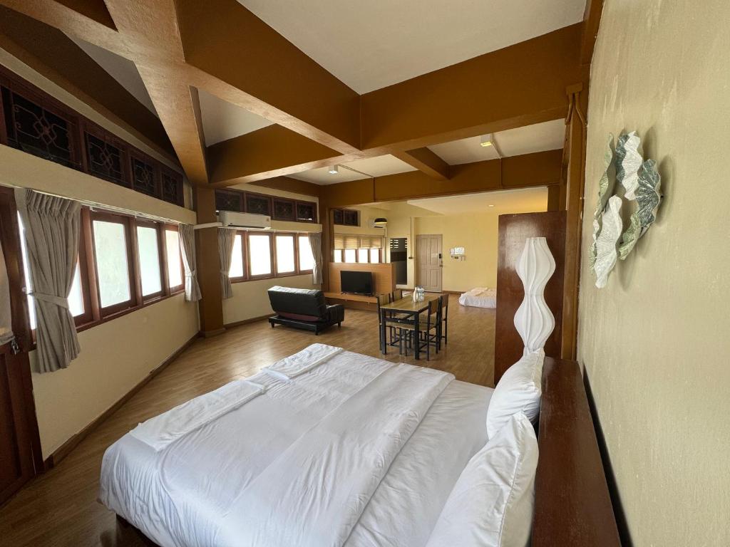 a bedroom with a bed and a living room at Sukstay Hotel in Bangkok