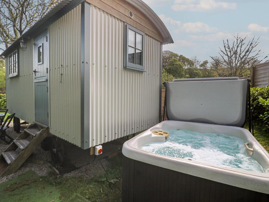 a bath tub sitting next to a shed at Godrevy Shepherds Hut in Hayle