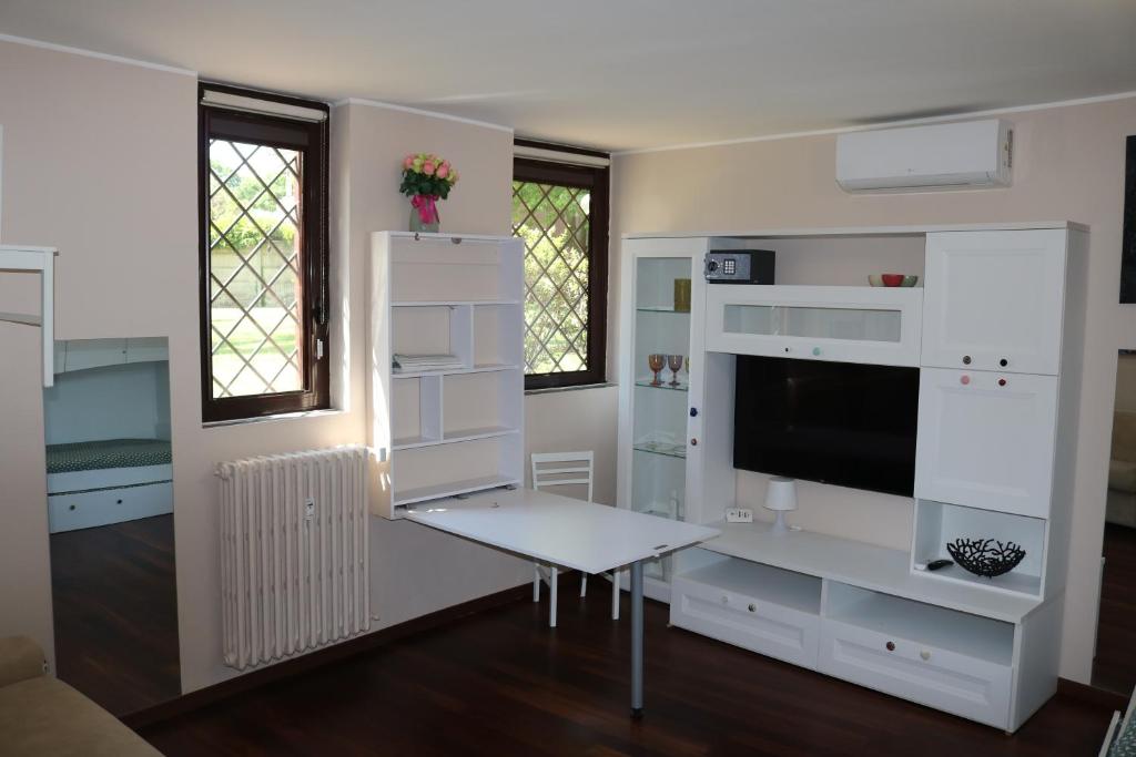 a living room with white furniture and a tv at Tevere 20 House in Monza