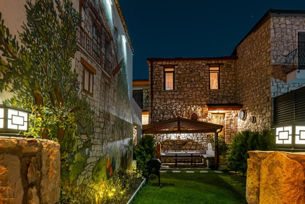 a stone house with a garden with a patio at Kösedere Stone Houses in Karaburun