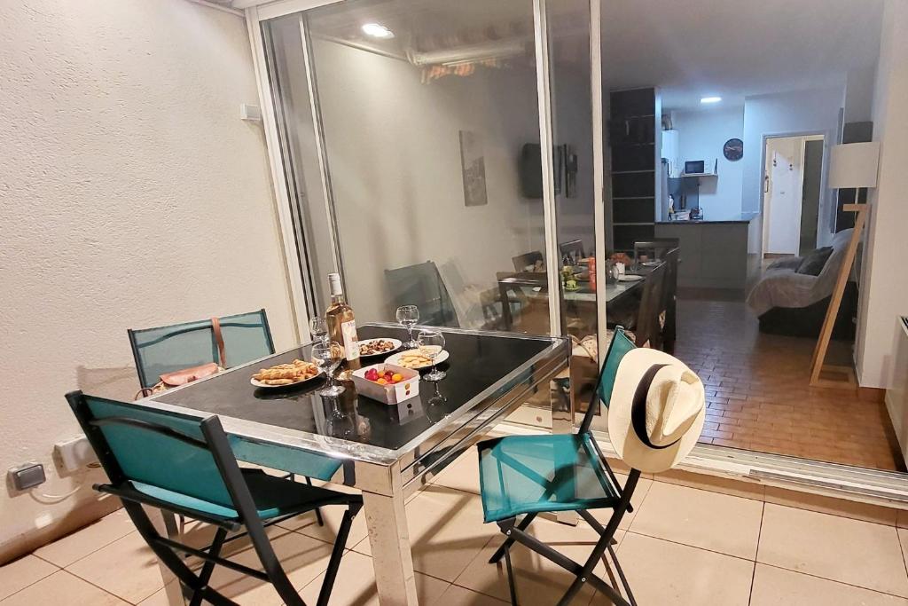 a kitchen with a table and chairs with food on it at Marina Nirvana vue sur l'eau in Le Grau-du-Roi
