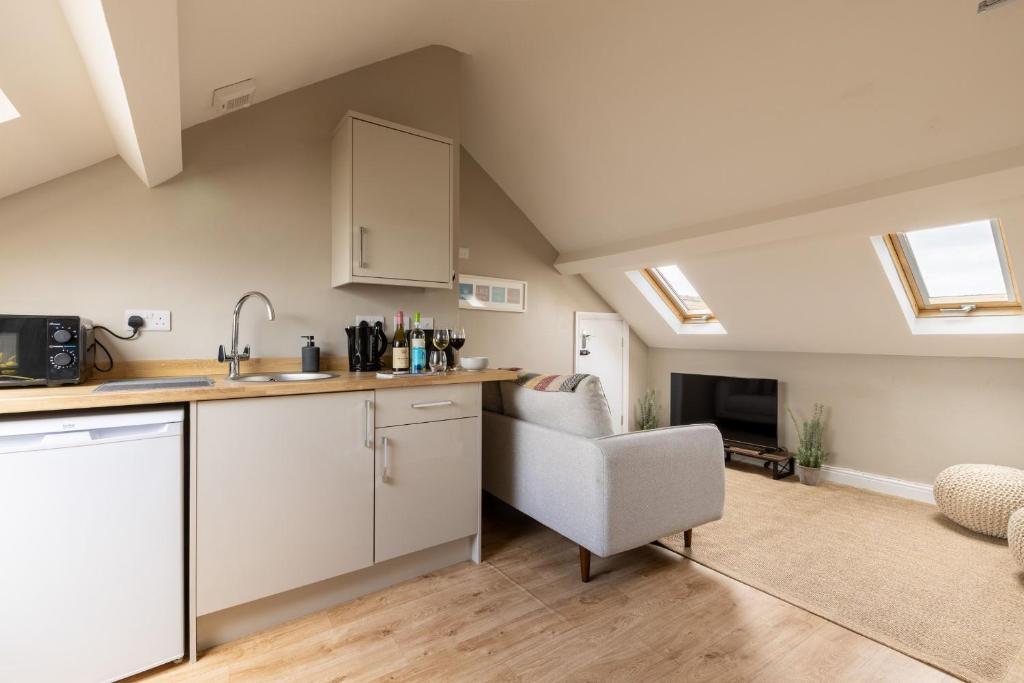 a kitchen with a sink and a chair in a room at The Wave - Room 15 in Rhosneigr
