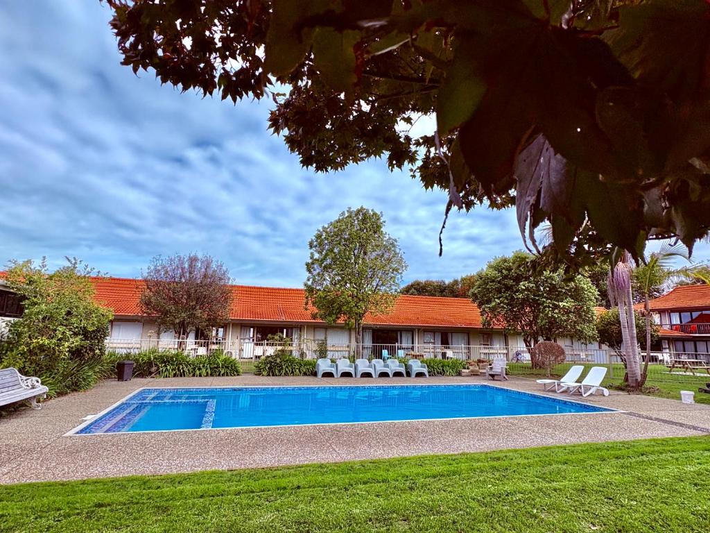 a swimming pool in front of a building at Airport Gold Star Motel in Auckland