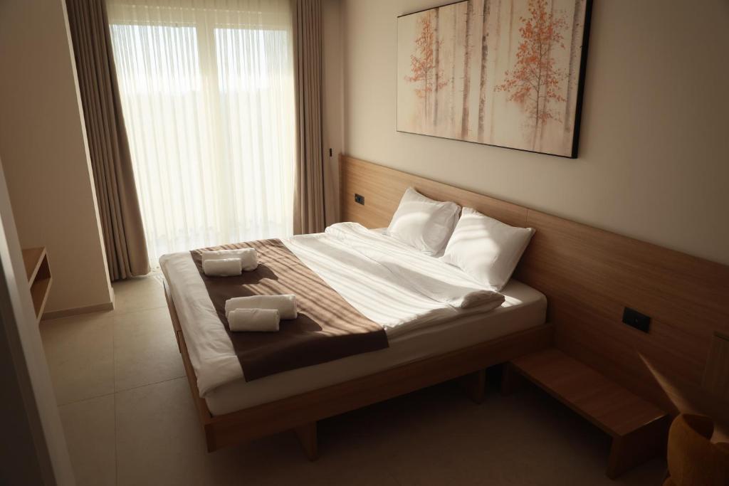 a bedroom with a bed with two towels on it at Hotel & Restaurant HAREA in Suharekë