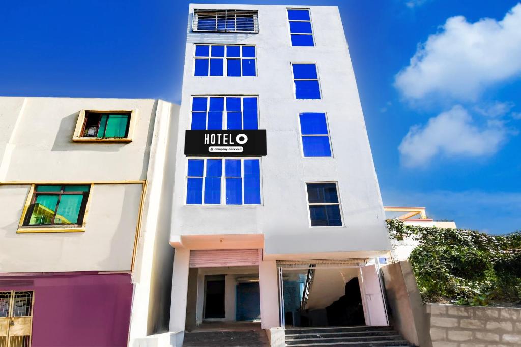 a tall white building with a sign on it at Hotel O Bhubaneshwar Near ITER College in Bhubaneshwar
