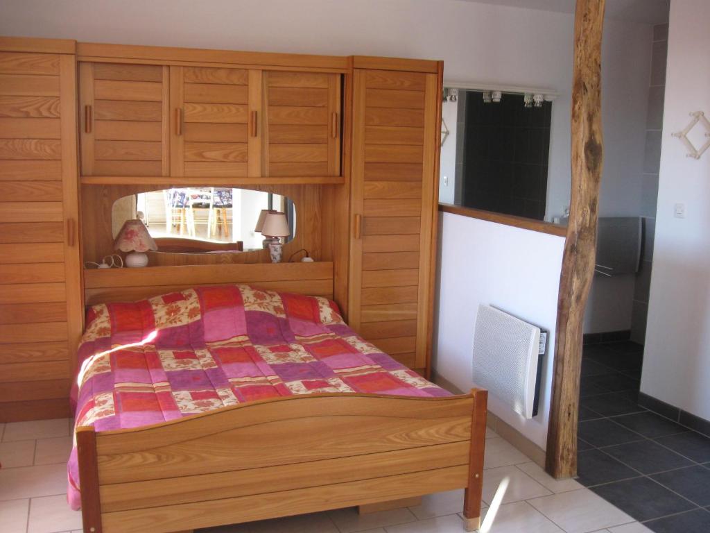 a bedroom with a bed with a wooden headboard at Les Genêts Valderois in Valderiès