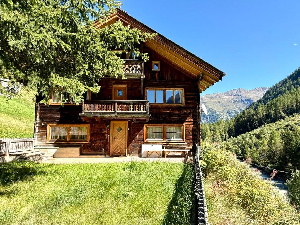 a log cabin in the mountains with a balcony at Haus Freistabl - Uriges Bauernhaus für 6 Personen mit Sauna & Bergblick im Ötztal in Sölden