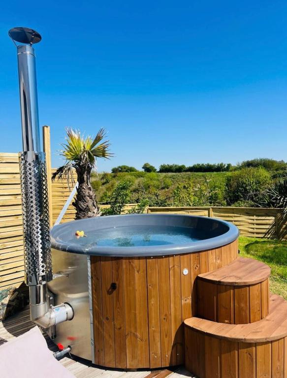 a wooden hot tub with a bench around it at Gîte grand confort 15 personnes - Le Domaine - Wimereux in Wimereux