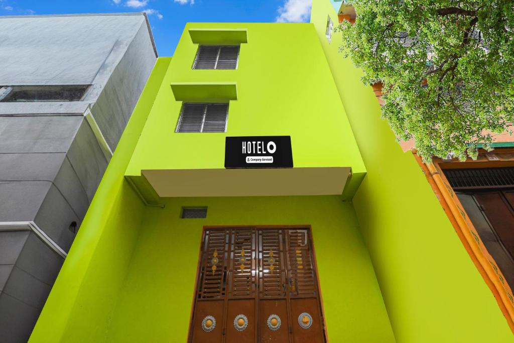 a green building with a sign above a door at Hotel O Dakshin Dwar Formerly Radha Krishna Niwas in Puri