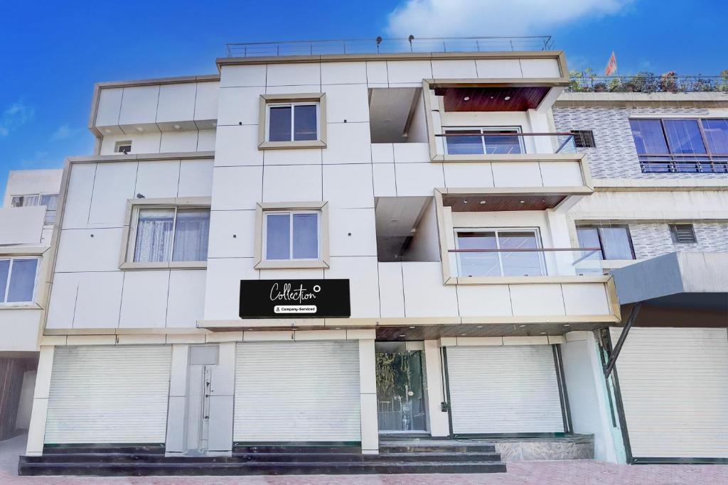 a white building with a black sign on it at Super Collection O Ganeshpuri Indore in Indore