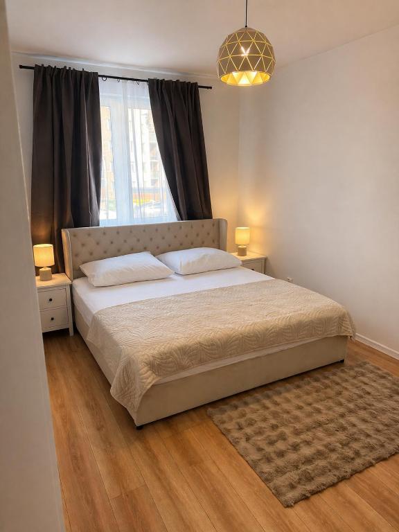 a bedroom with a large bed and a window at PikApart in Olsztyn