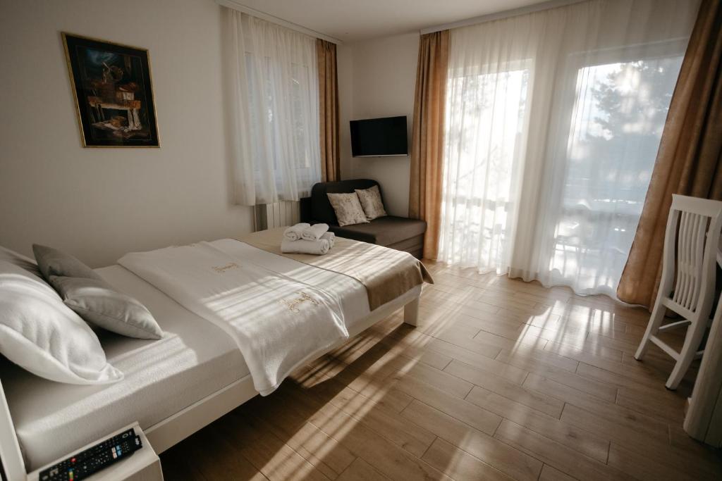 a bedroom with a bed and a chair and a window at Markov Konak in Divčibare