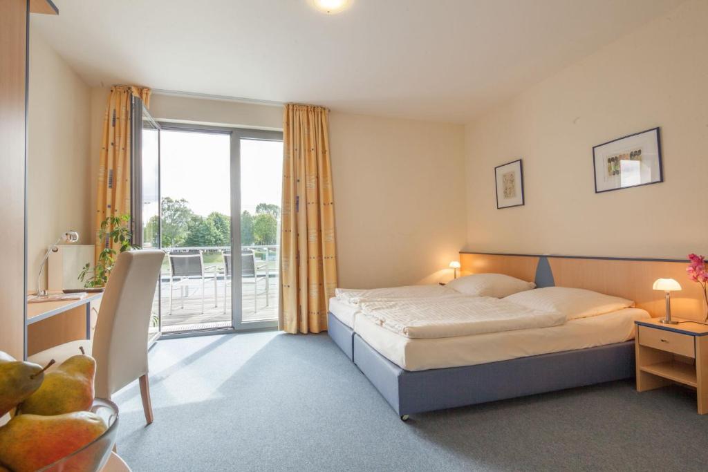 a hotel room with a bed and a balcony at Tunici Team Hotel in Hamburg