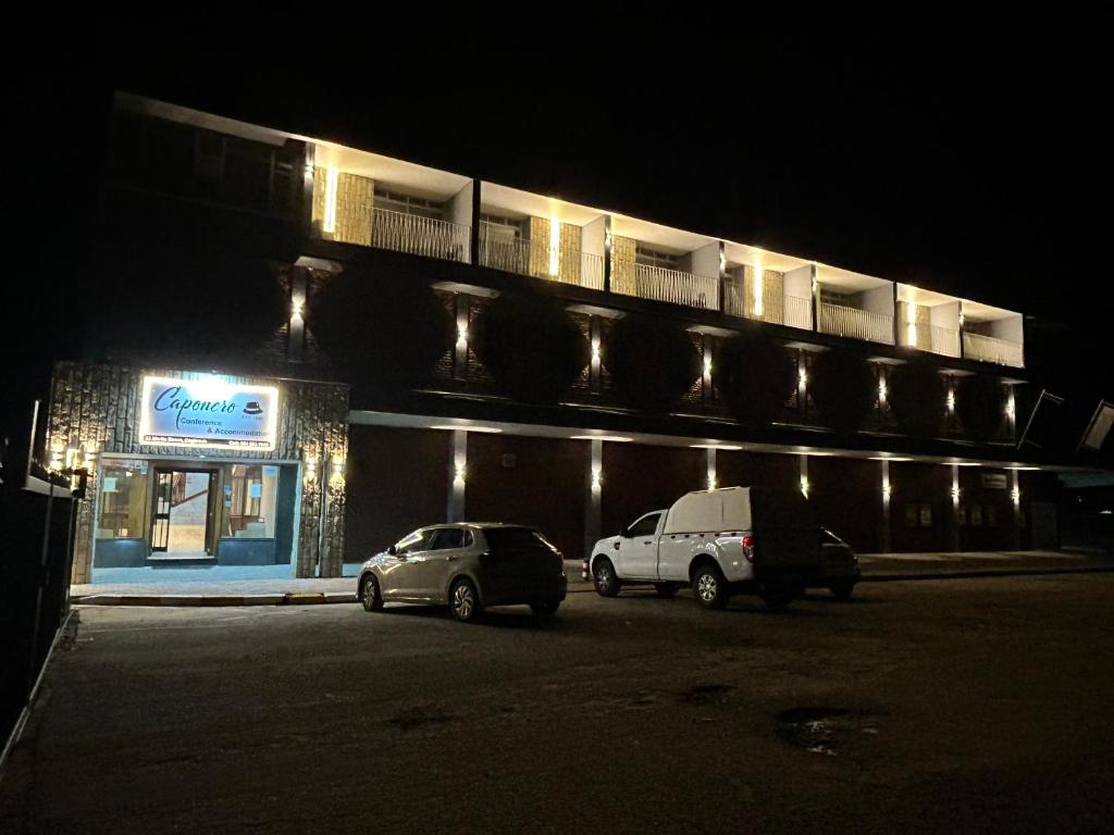 two cars parked in front of a building at night at Caponero accommodation conference in Welkom