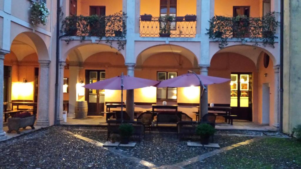 a courtyard with tables and umbrellas in a building at Archi e Colonne in Verbania