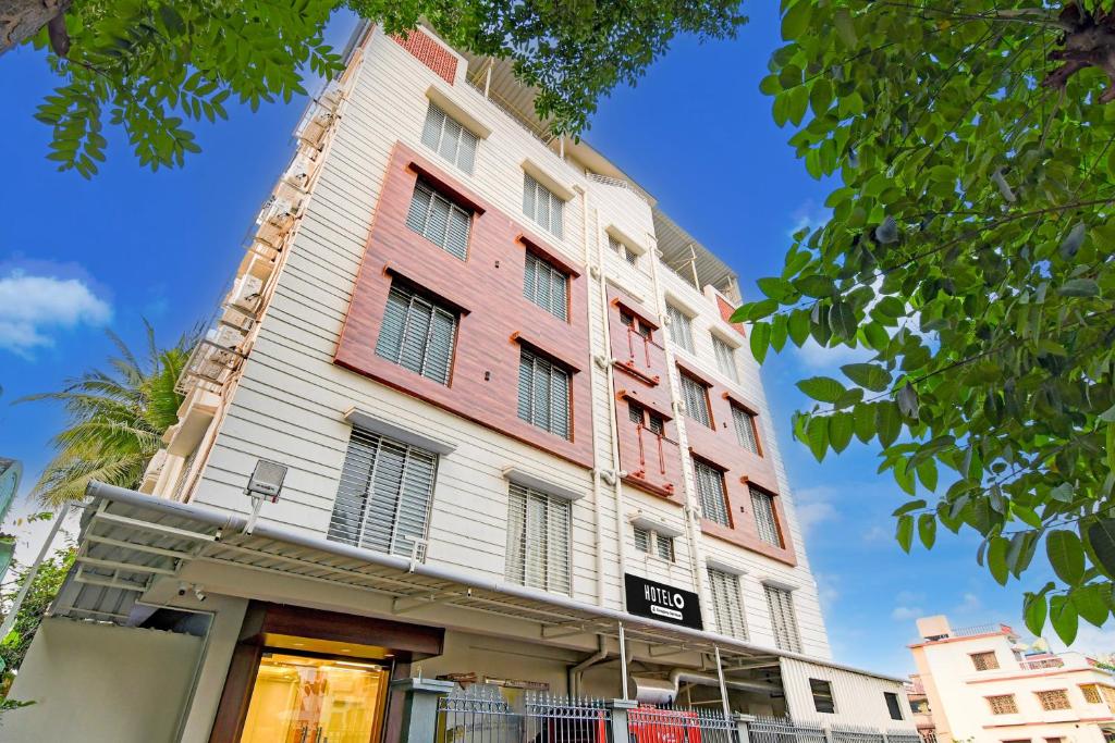 a tall building with red and white at Super Townhouse Kaikhali Near Airport in Kolkata