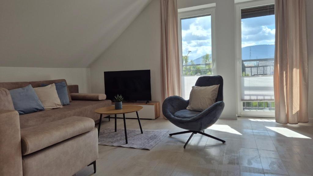 a living room with a couch and a chair and a television at Apartamenty Bujowy in Ustroń