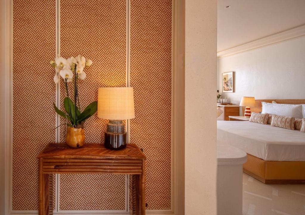 a bedroom with a bed and a table with flowers on it at Mandarin Oriental Punta Negra, Mallorca in Palmanova