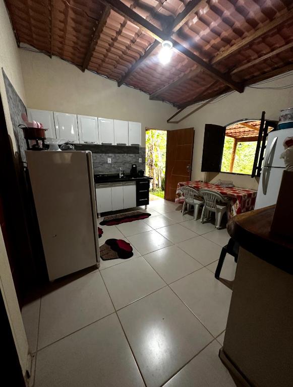 a kitchen with an open refrigerator and a table at Chácara nosso pedacinho do céu in Domingos Martins