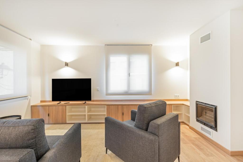 a living room with a tv and a couch and a chair at Be1960 tercer in Bagá