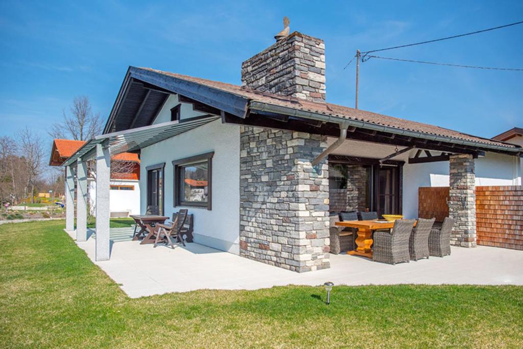 a small brick house with a patio and a table at Fischerhaus am Moosbach mit Sauna in Mietenkam