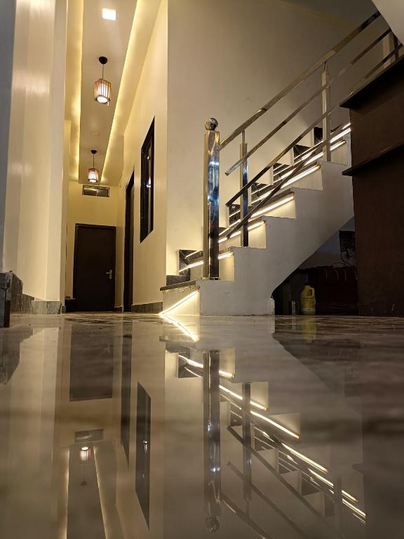 a lobby with a staircase and a shiny floor at Gita Raman Palace in Ayodhya