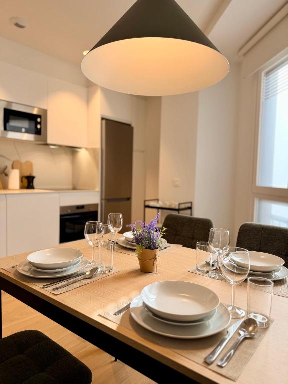a dining room table with plates and wine glasses at Apartamentos DORRE LUZEA Apartamentuak in Zarautz