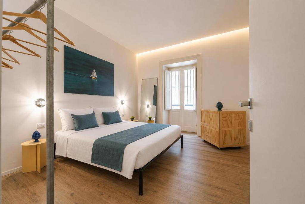 a bedroom with a large white bed and a window at Palazzo Lucatelli Suite - Centro in Trapani