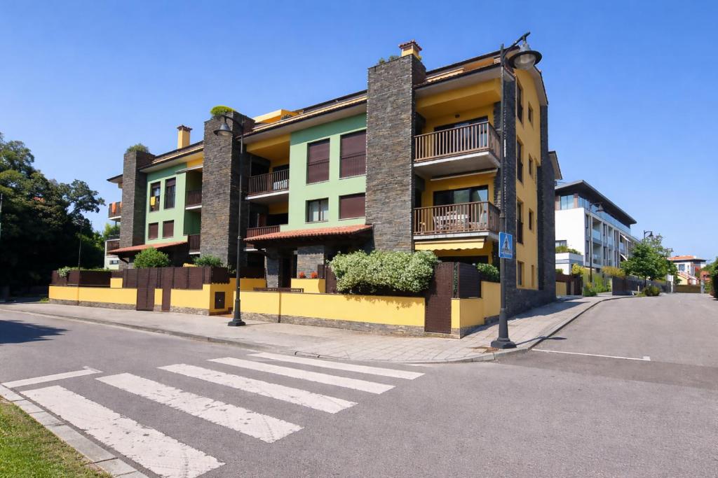 a building on the side of a street with a crosswalk at Apto Llanes Bajo con terraza - Casa Juanín in Llanes