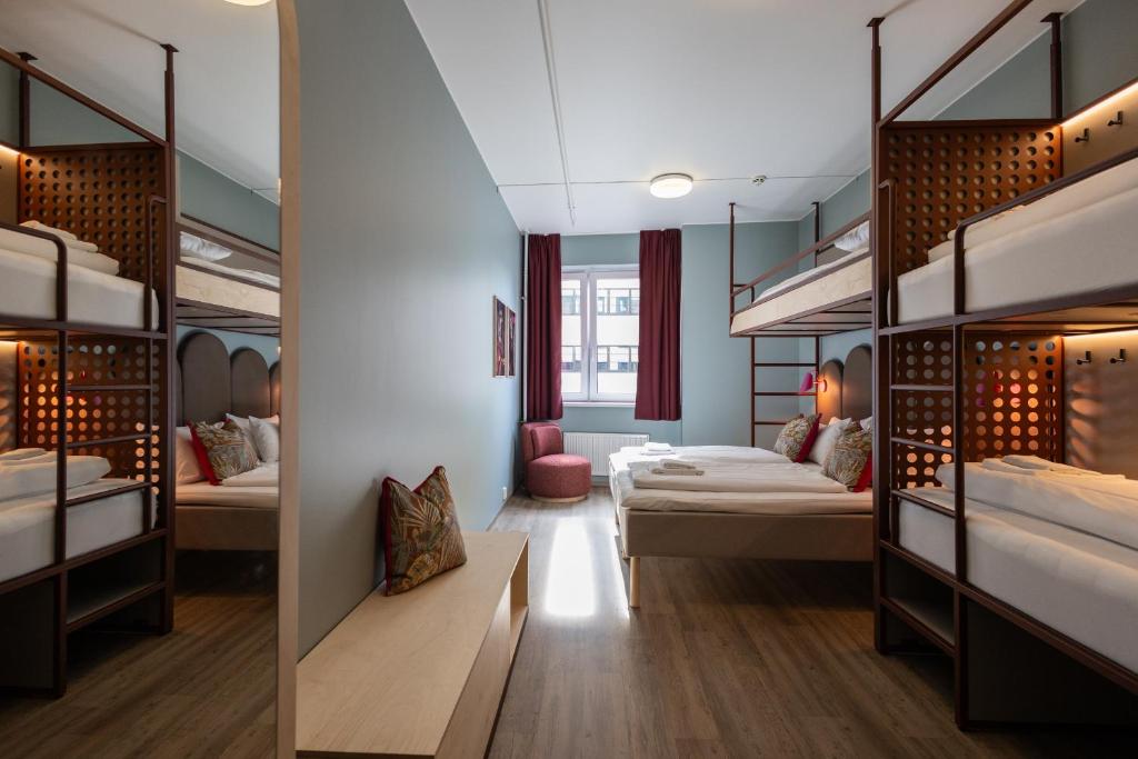 ein Schlafsaal mit Etagenbetten und einem Tisch in der Unterkunft Bunks at Rode in Oslo