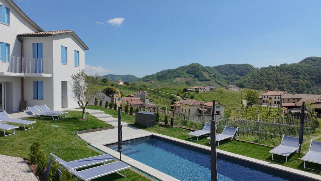 a villa with a swimming pool and a house at Villa Valdobbiadene Pool Spa in Valdobbiadene