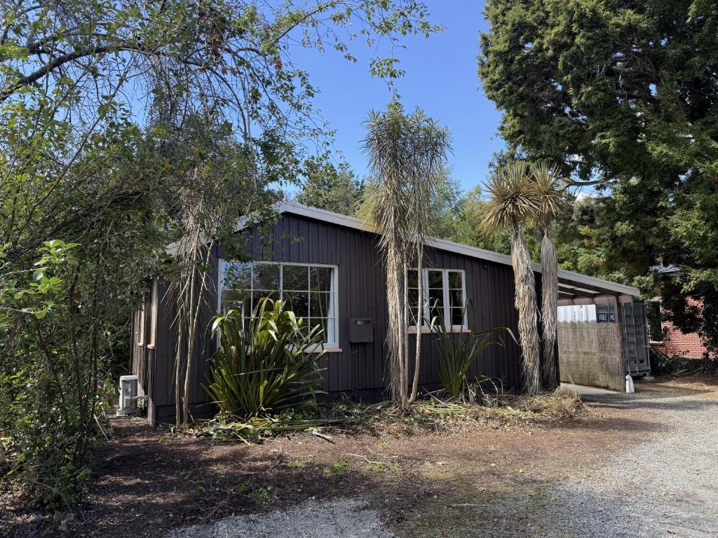 a black building with trees in front of it at Thyme On The Terrace in Te Anau