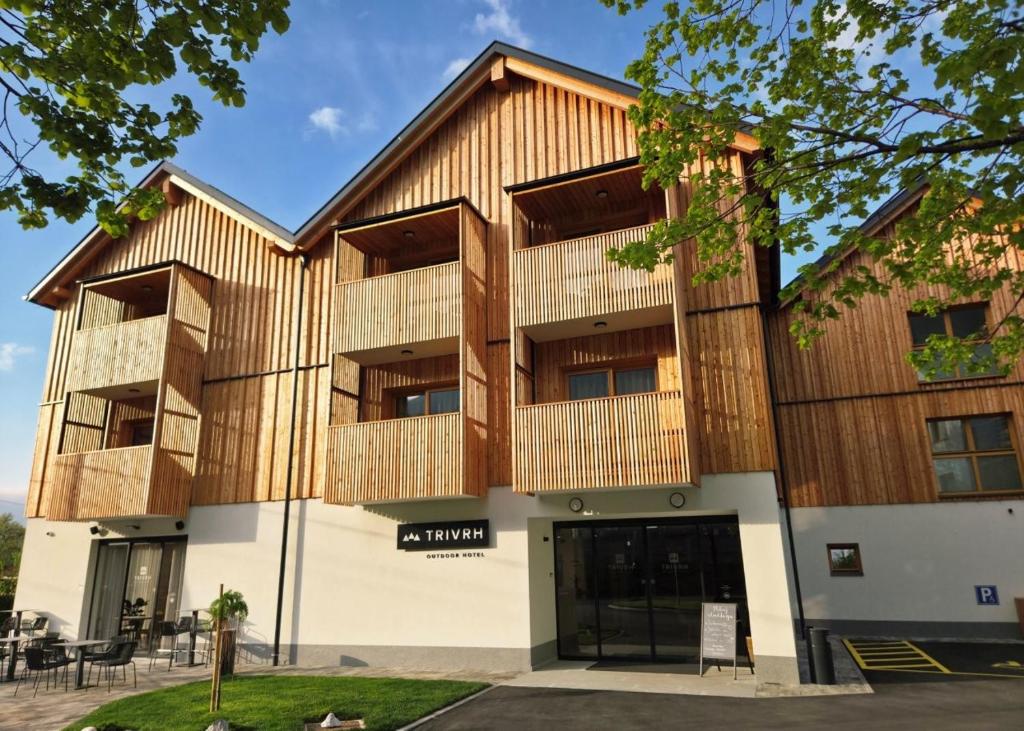 a building with wooden panels on the side of it at Trivrh Outdoor Hotel in Žirovnica