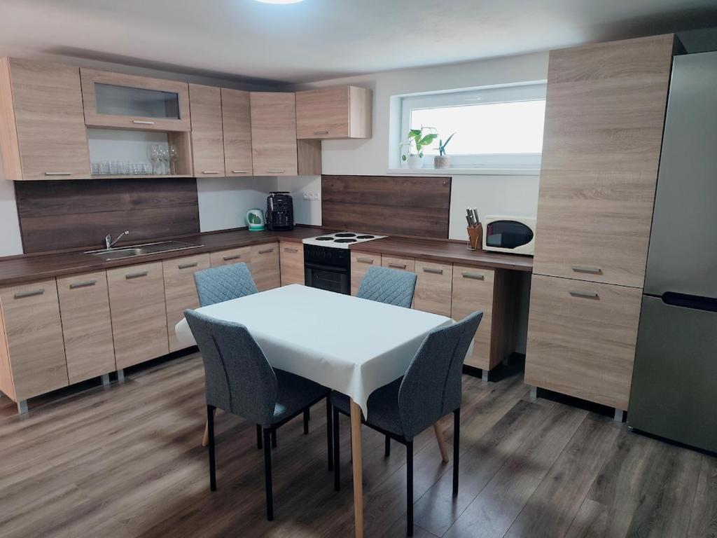 a kitchen with a white table and chairs in it at Dom priamo pri rieke in Opatovce nad Nitrou