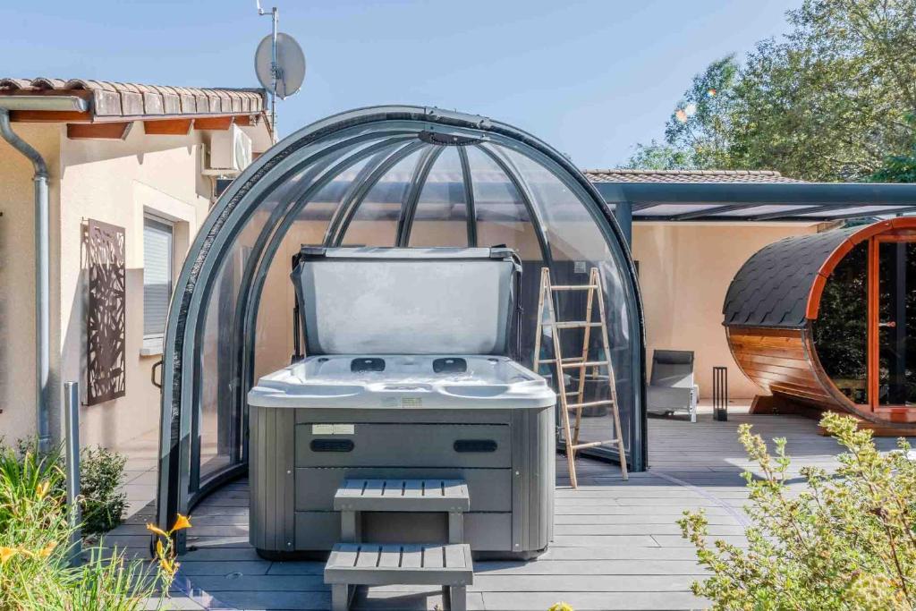 a bbq grill in front of a gazebo at L'Escale Sud Gironde - Séjour en amoureux avec jacuzzi privatif - Piscine - Massage Traiteur & Brunch possibles in Pompéjac