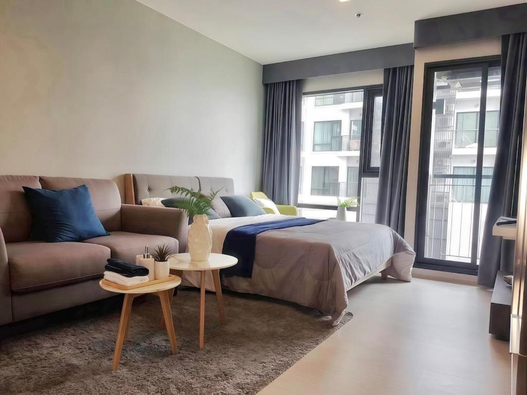 a bedroom with a bed and a couch at Thong Lor condo Next to BTS in Bangkok