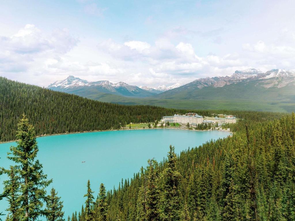 a view of a blue lake with mountains in the background at Fairmont Château Lake Louise in Lake Louise