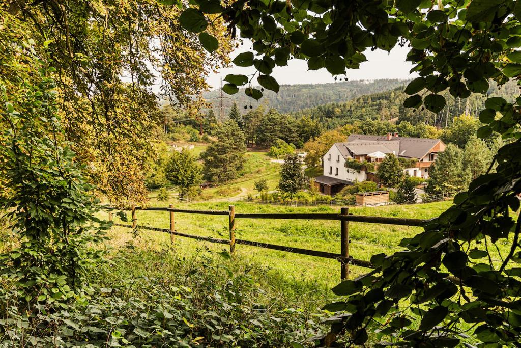 a wooden fence in a field with a house at Statek Samsara in Blansko