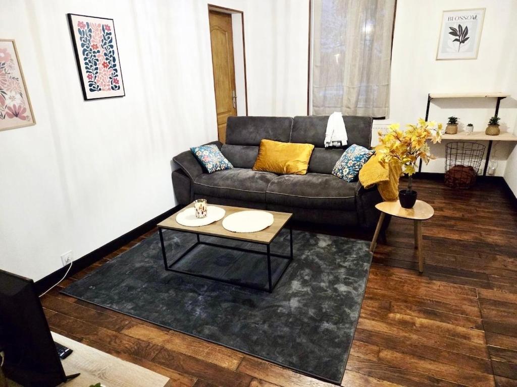 a living room with a couch and a table at Bohéme Chic in Saint-Dizier