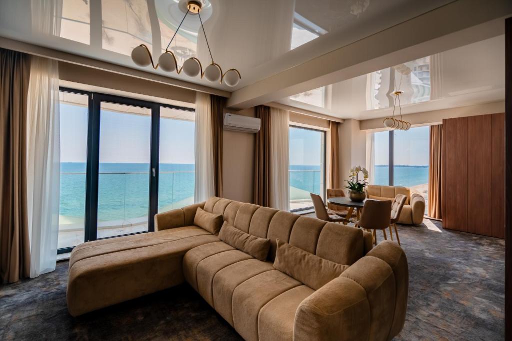 a living room with a large couch and a table at Noble Hotel by Building Stefan in Mamaia Sat/Năvodari