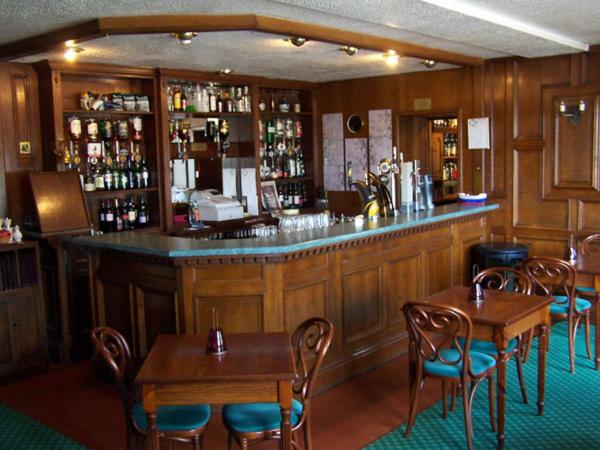 a bar with tables and chairs in a restaurant at Lochgair Hotel in Lochgair