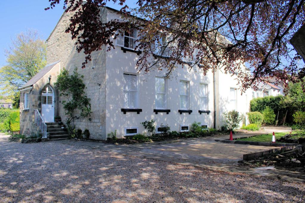 a large white building with a tree in front of it at Collins House in Knaresborough