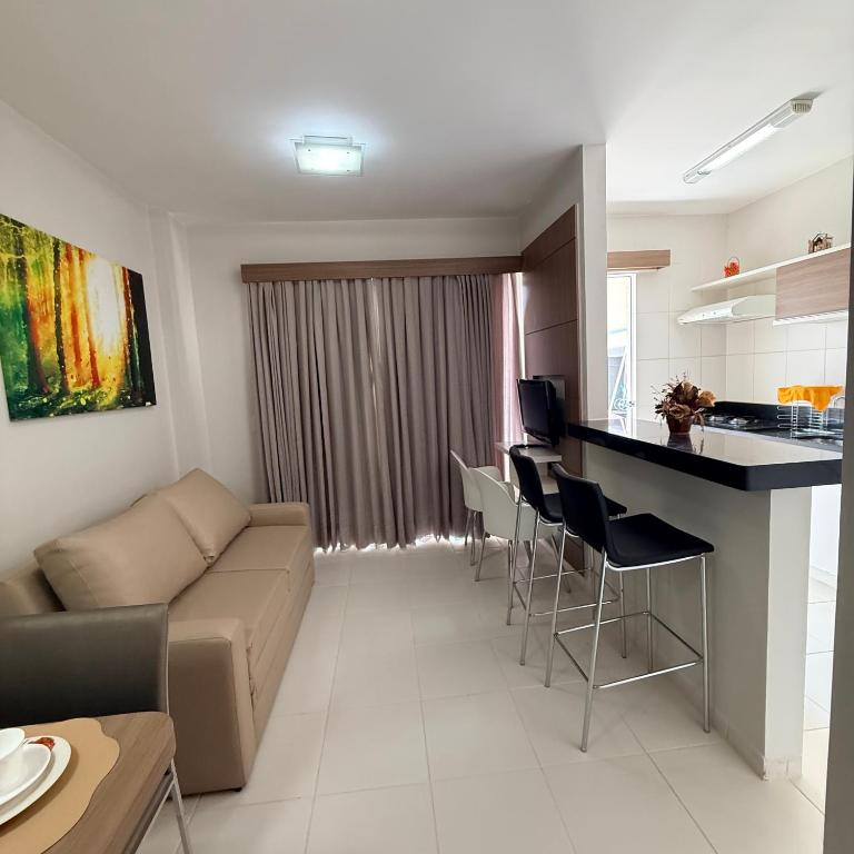 a living room and kitchen with a couch and a table at Veredas Do Rio Quente Flat Service 723 in Rio Quente