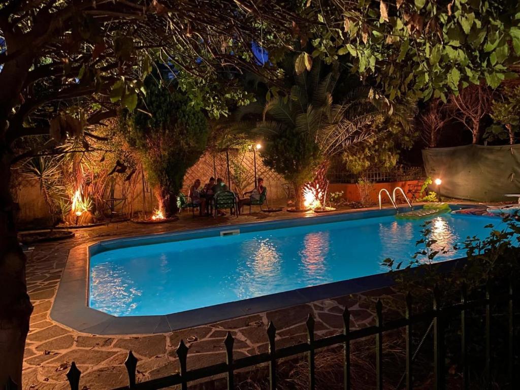 a swimming pool with lights in a backyard at night at Ancient Olympia Luxury Pool Villa Palace 4Bedroom in Olympia