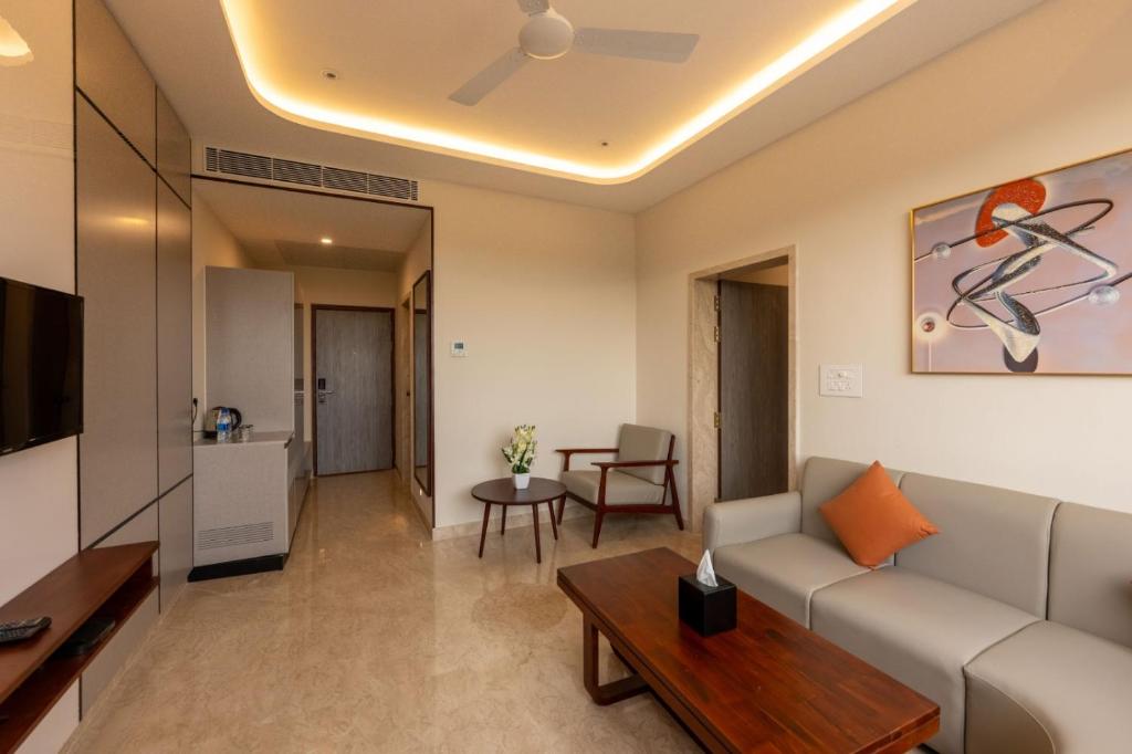 a living room with a couch and a table at Fortune Village Hotel in Kundapur